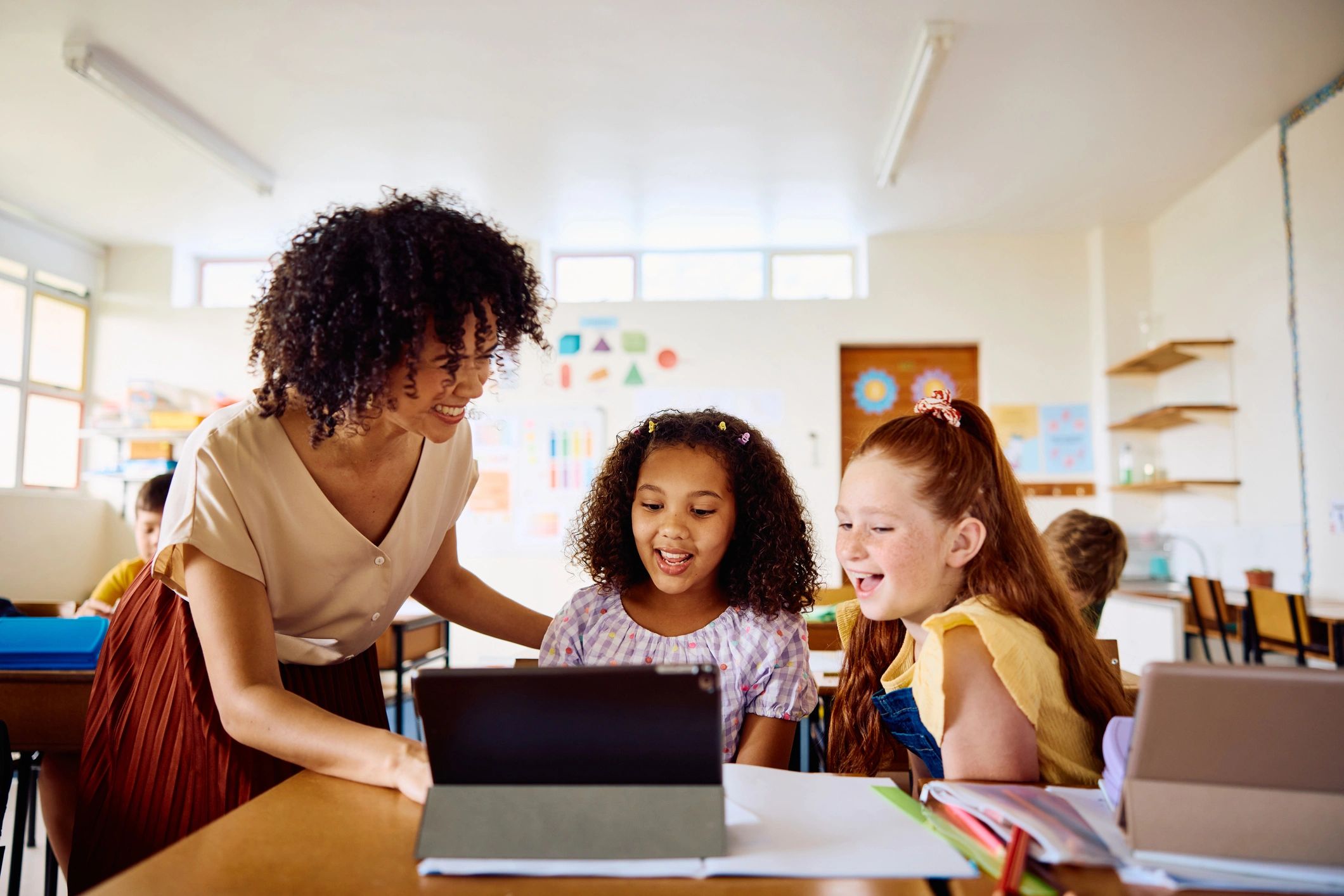 Teacher helping students with a tablet during class