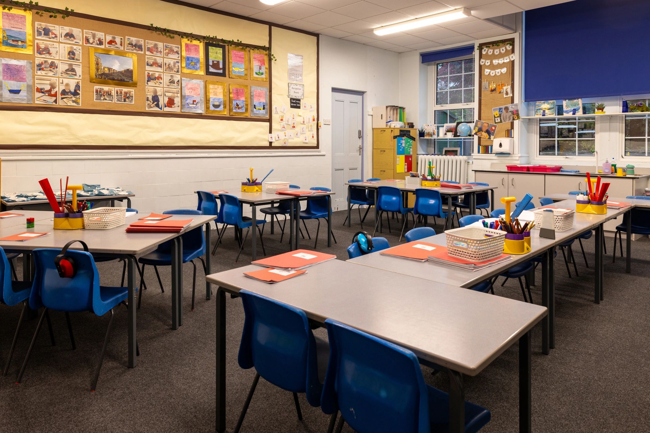 Empty classroom prepared with supplies on desks
